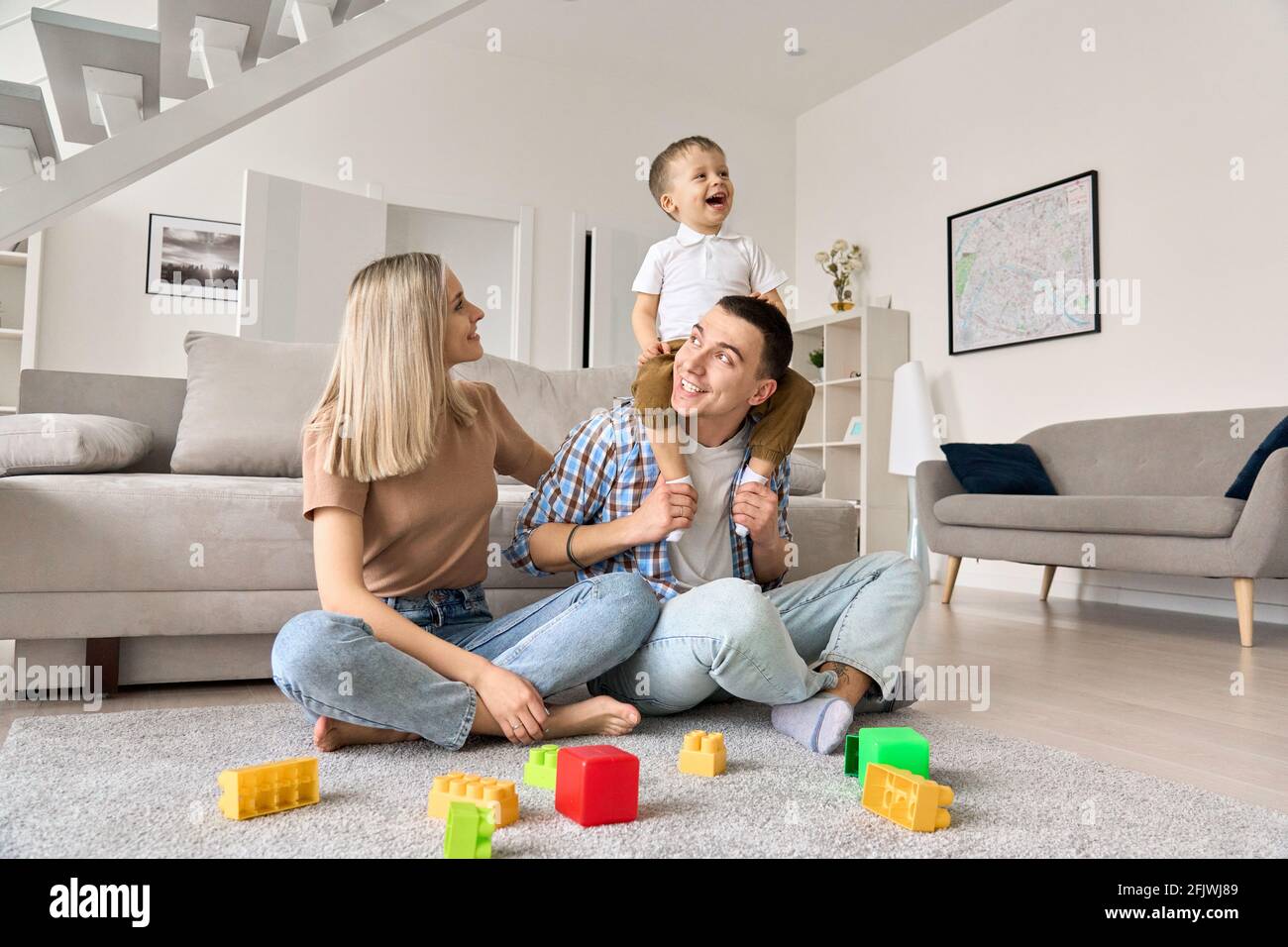 La famiglia felice con il figlio del bambino del toddler che gode passare il tempo insieme a casa. Foto Stock