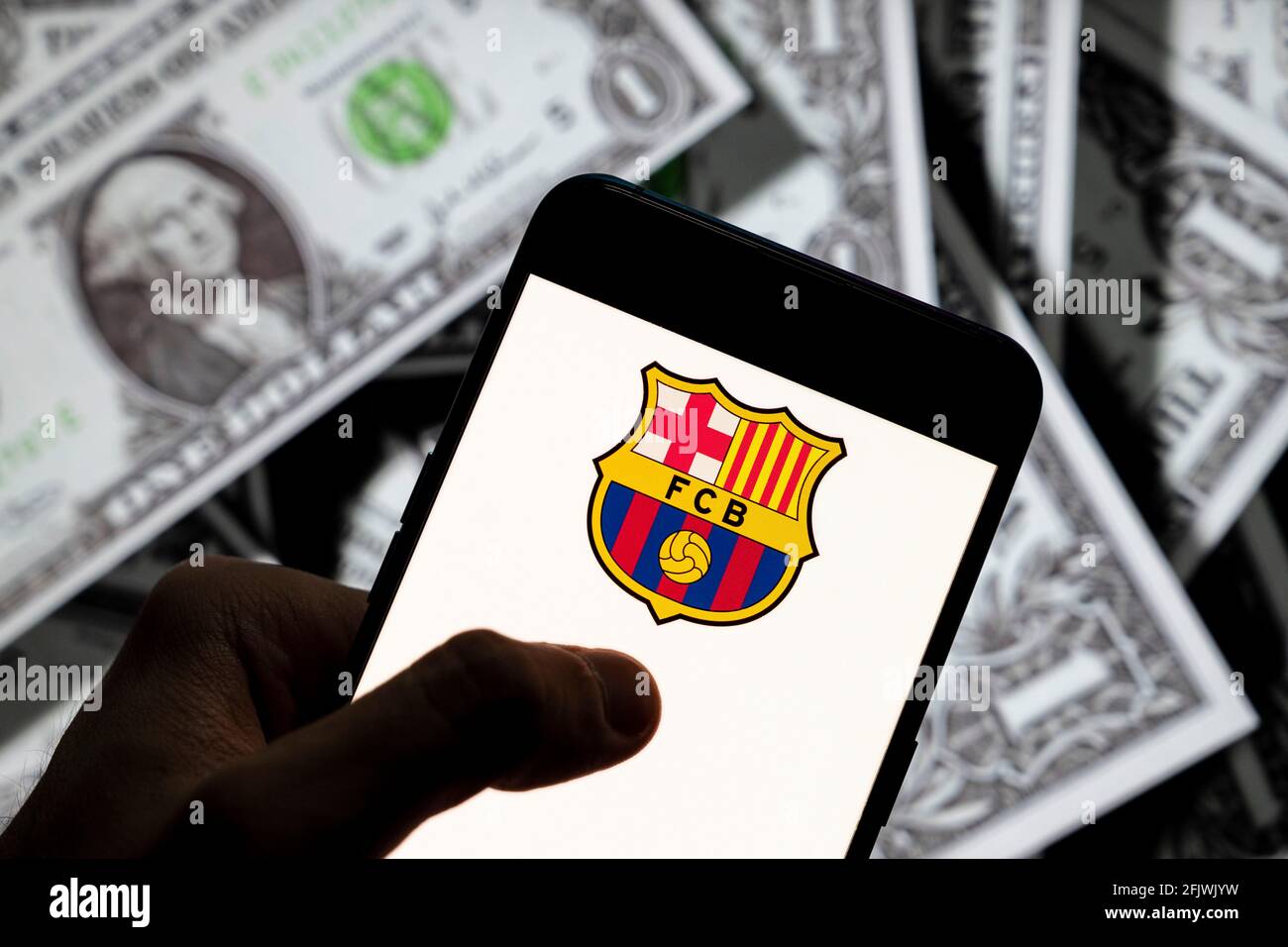 In questa illustrazione la squadra di calcio professionista spagnola il logo Futbol Club Barcelona visto su uno smartphone con la valuta USD (dollaro USA) sullo sfondo. Foto Stock