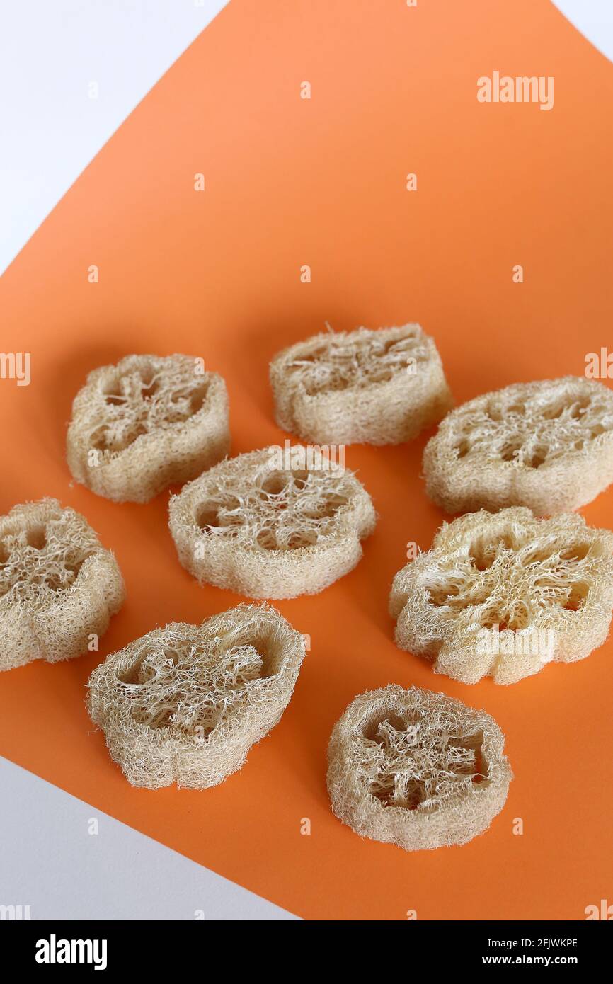 Spugne di loofah naturali su sfondo arancione. Foto Stock