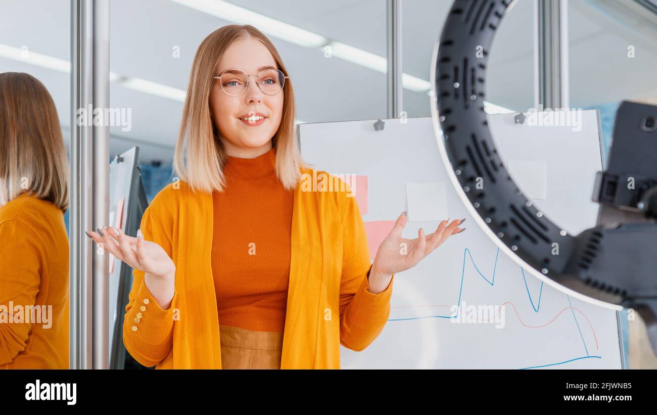 L'insegnante online registra le lezioni video. Il manager effettua la presentazione durante la riunione online. Donna dietro grafica su lavagna. Lavoro remoto. Allenate il Mentor Foto Stock