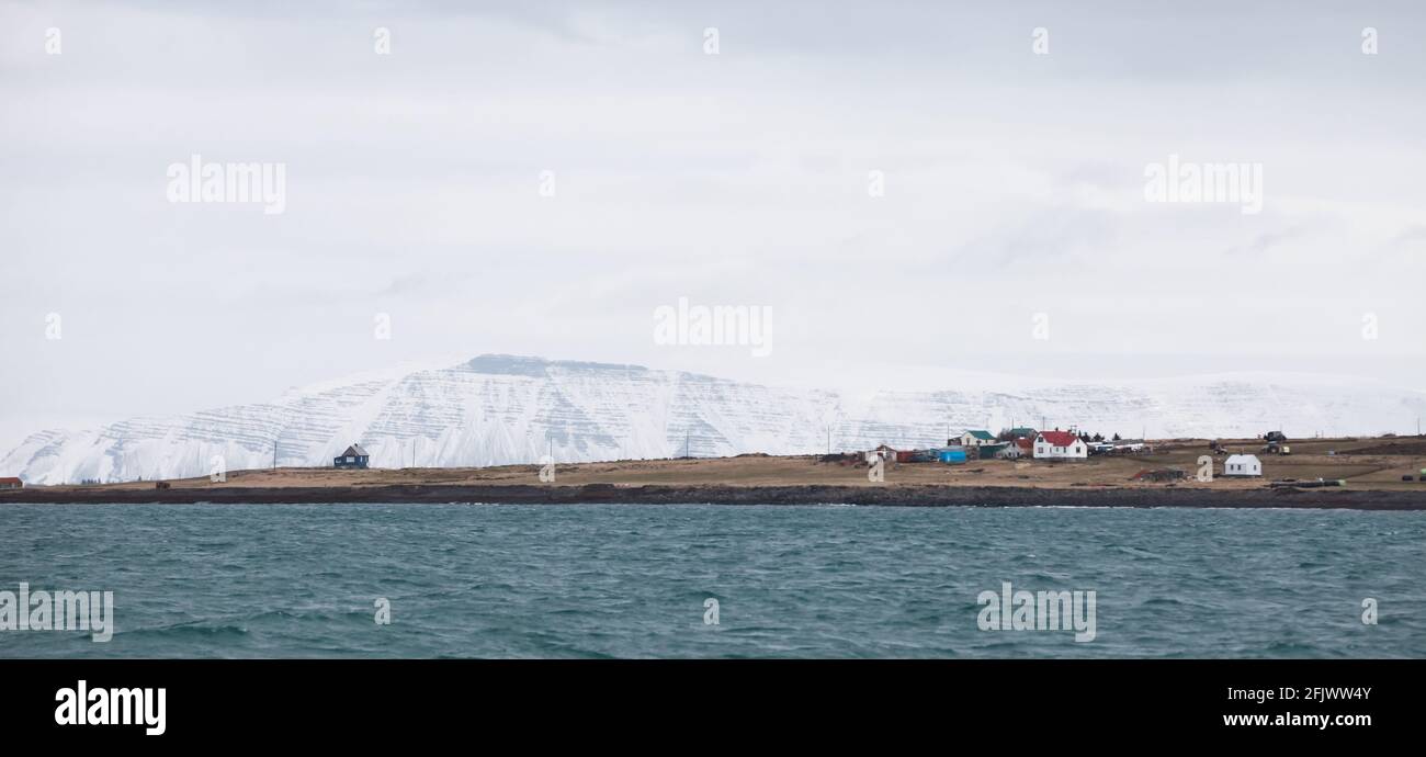Reykjavik, Islanda, paesaggio panoramico costiero. Montagne innevate sotto il cielo nuvoloso Foto Stock