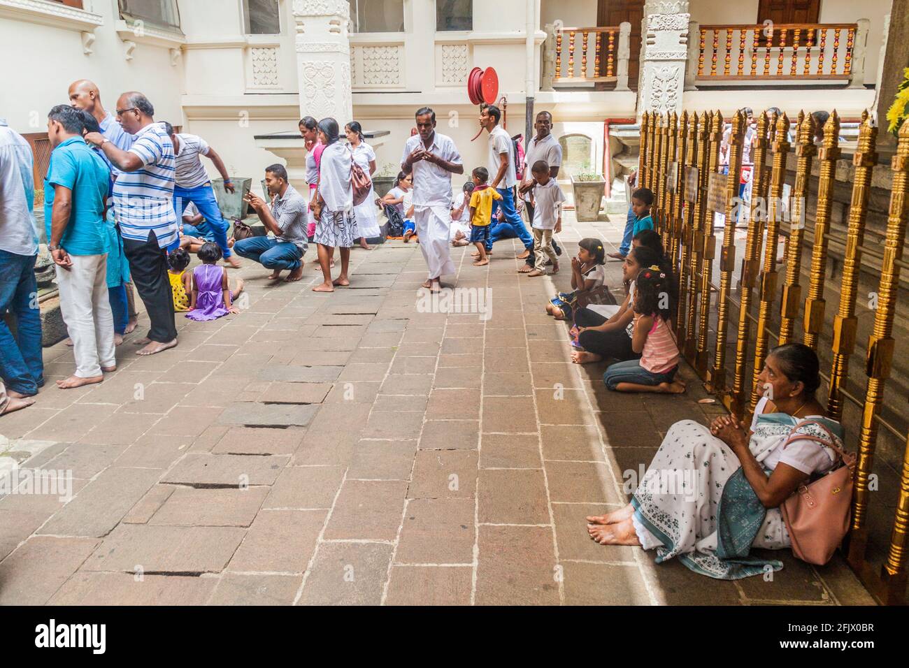 KANDY, SRI LANKA - 19 LUGLIO 2016: I devoti buddisti vestiti bianchi pregano nel Tempio della Reliquia del dente Sacro durante la festa della Luna piena di Poya. Foto Stock