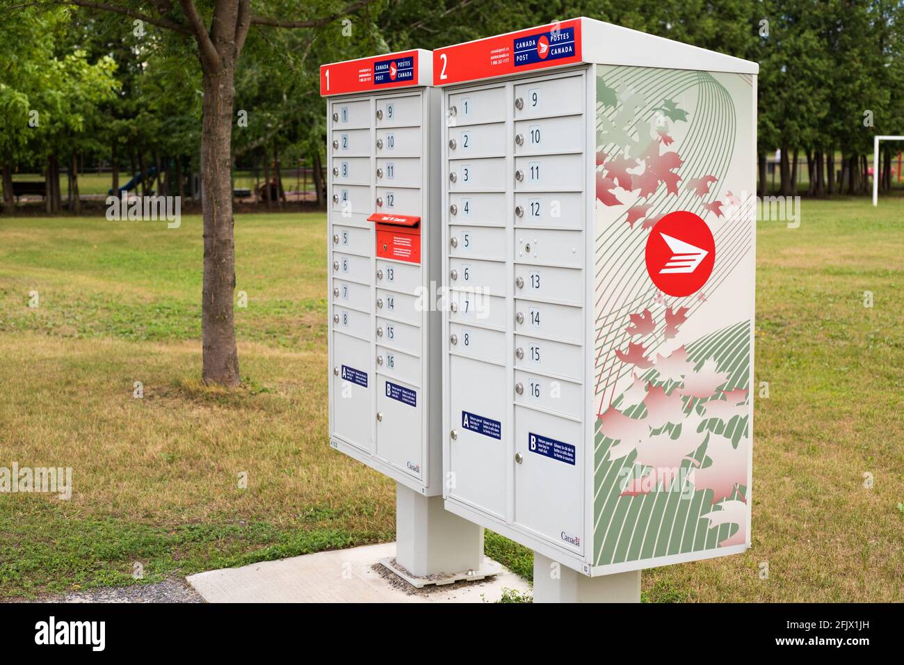 Ottawa, Canada - 17 aprile 2021: Canada caselle postali impostate nella comunità di quartiere vicino al parco con un cartello rosso in inglese e francese Foto Stock