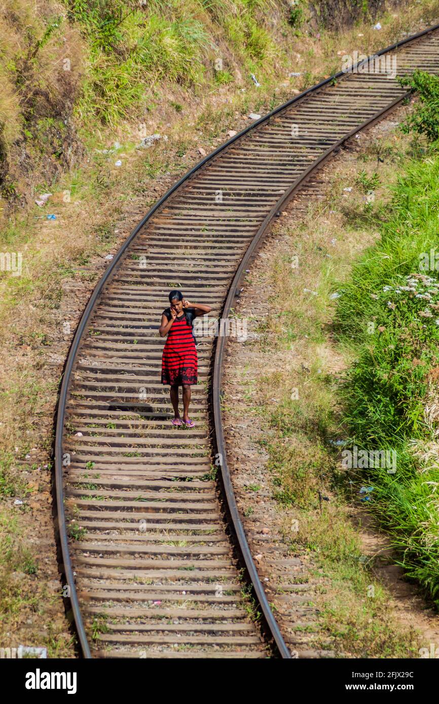 HAPUTALE, SRI LANKA - 16 LUGLIO 2016: Donna locale cammina sulle piste ferroviarie vicino Haputale. Foto Stock
