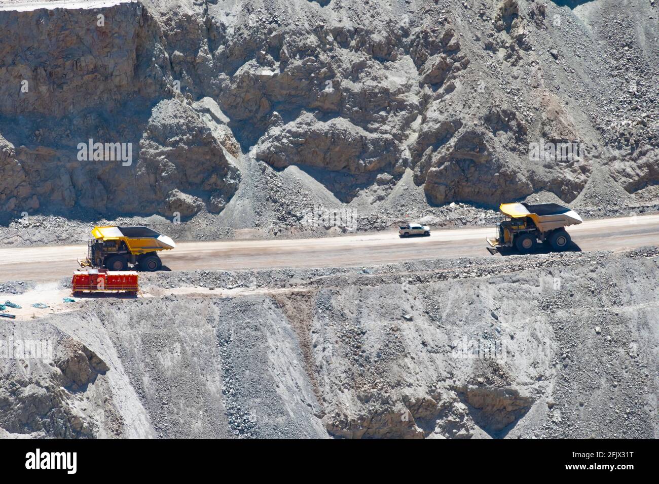 Camion a grande raggio e macchinari che lavorano a Chuquicamata, la più grande miniera di rame a cielo aperto del mondo, Calama, Cile Foto Stock