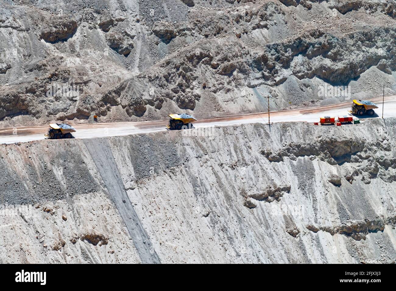 Camion a grande raggio e macchinari che lavorano a Chuquicamata, la più grande miniera di rame a cielo aperto del mondo, Calama, Cile Foto Stock