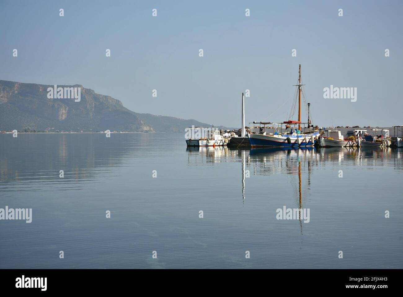 Paesaggio con vista porto e le barche da pesca greche di Poulithra, un villaggio tradizionale in Arcadia Peloponneso, Grecia. Foto Stock