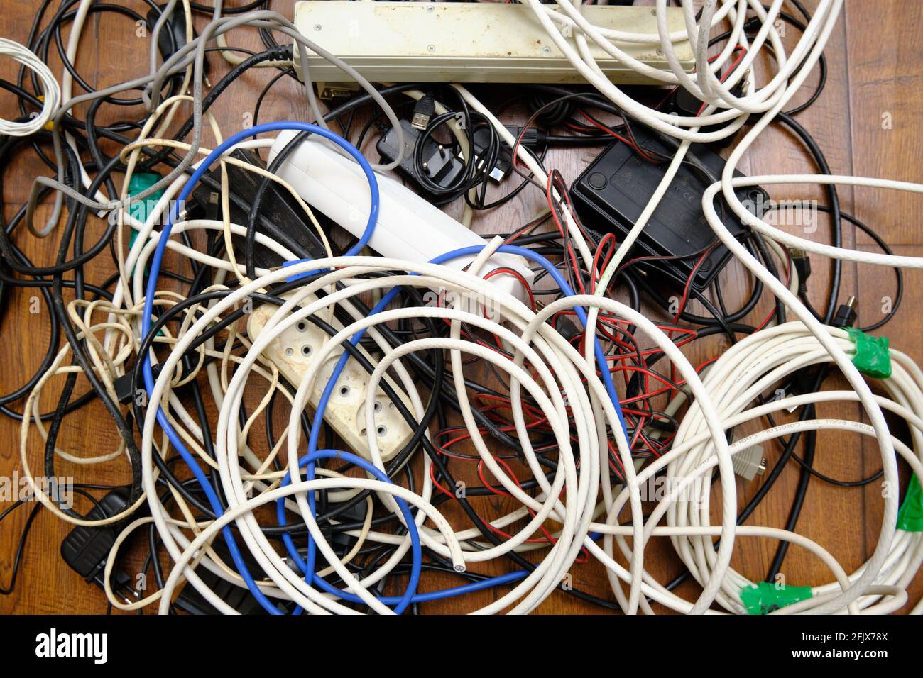 Un groviglio di fili non necessari si trova sul pavimento. Foto Stock