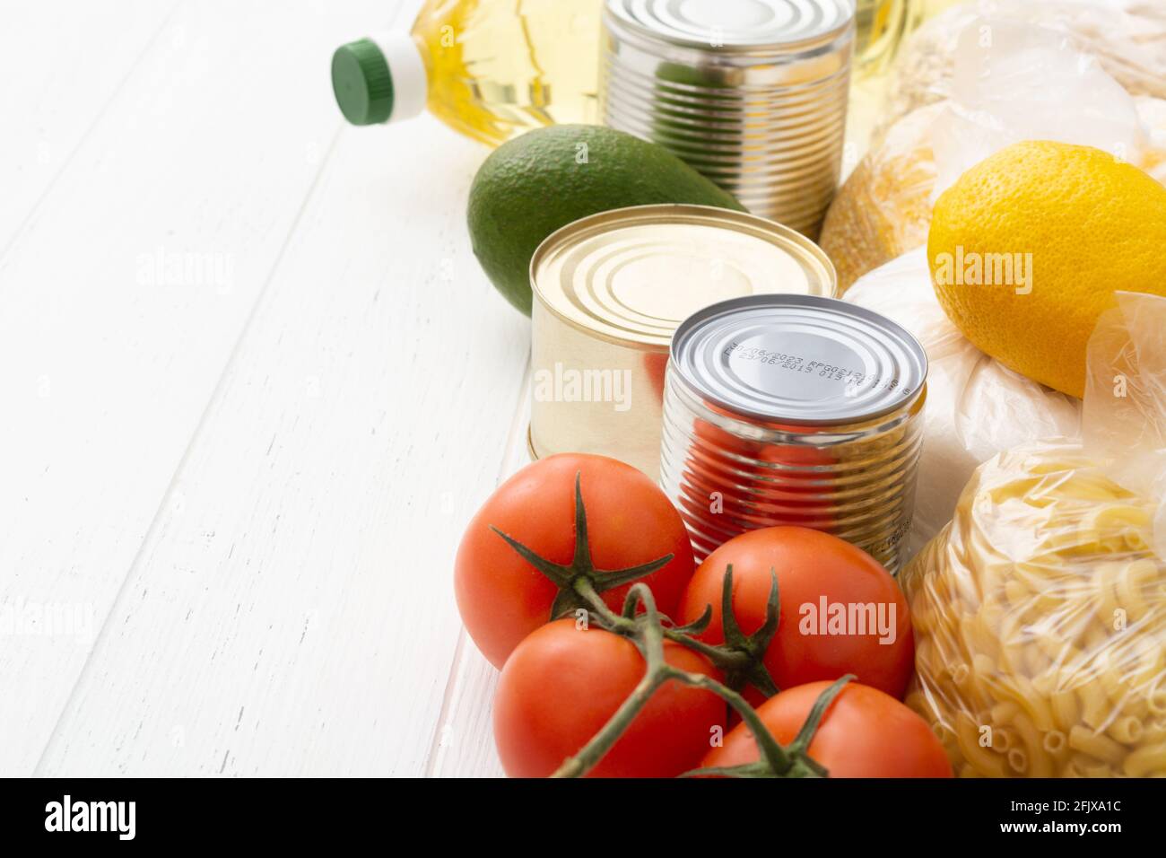 Vari alimenti su tavola di legno bianco. Donazione di cibo Foto Stock