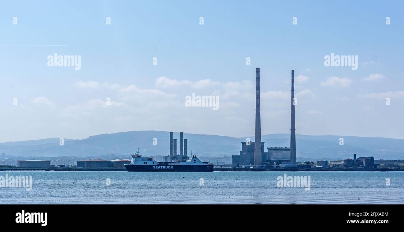 Un traghetto Seatruck che entra nel porto di Dublino passando per i camini della vecchia centrale elettrica di Poolbeg e il nuovo inceneritore. Foto Stock