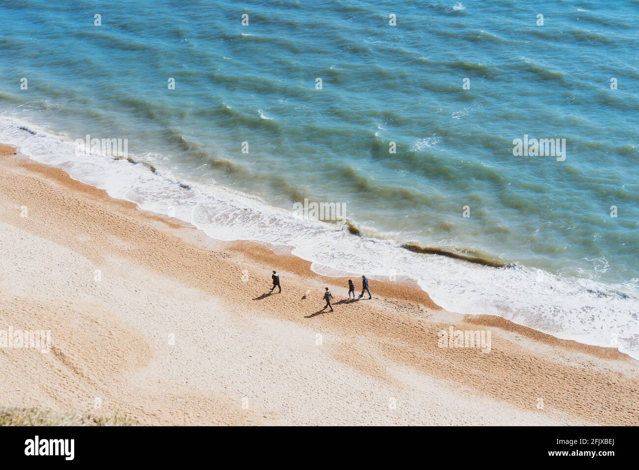 Aereo Vista dall'alto famiglia camminando sulla spiaggia in una giornata di sole. Calma e godendo la vita. Benessere emozionale. La felicità è nelle cose semplici. Spazio di copia Foto Stock