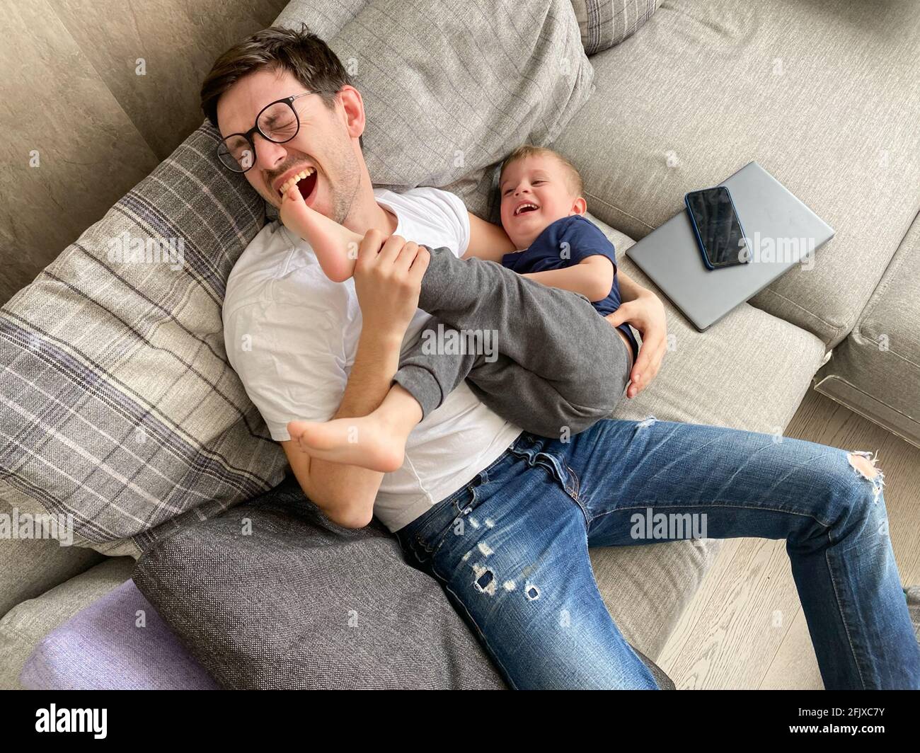 Padre gioca con suo figlio mentre riposa dai gadget isolamento Foto Stock