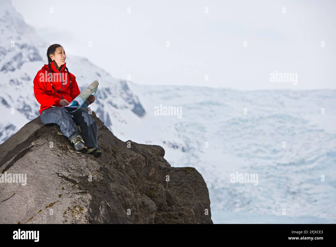 Mappa di lettura delle escursioni femminili sulla roccia sopra il ghiacciaio Foto Stock