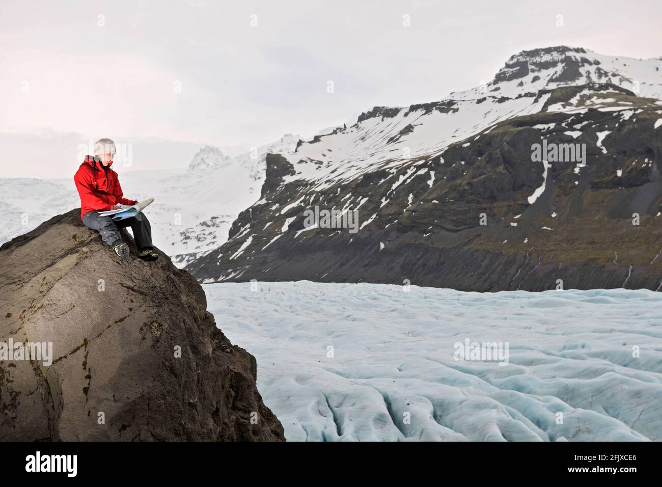 Mappa di lettura delle escursioni femminili sulla roccia sopra il ghiacciaio Foto Stock