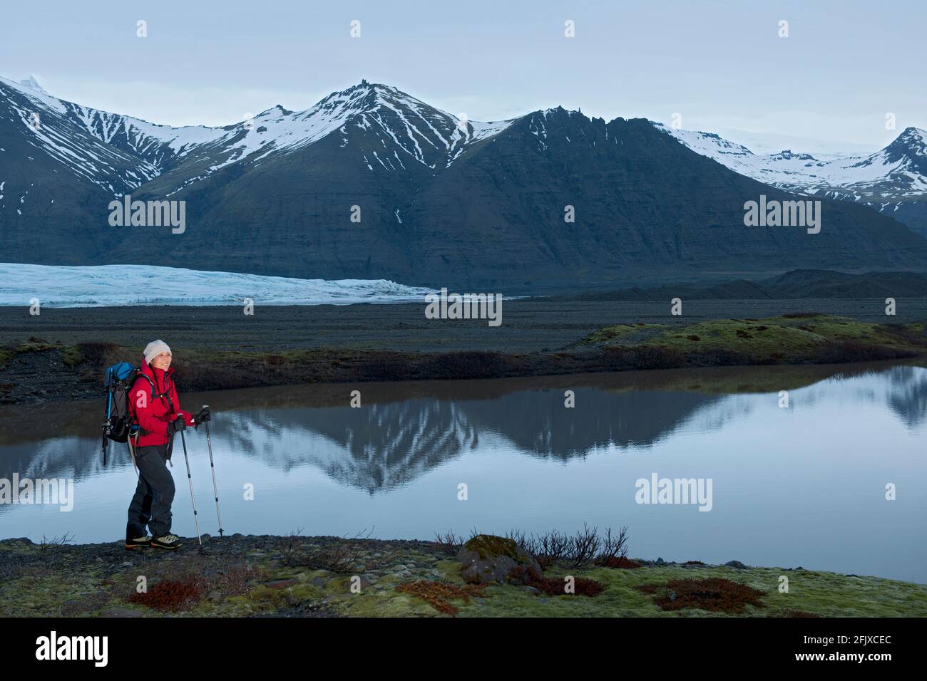 Trekking femminile escursionista attraverso il paesaggio arido a Skaftafell / Islanda Foto Stock