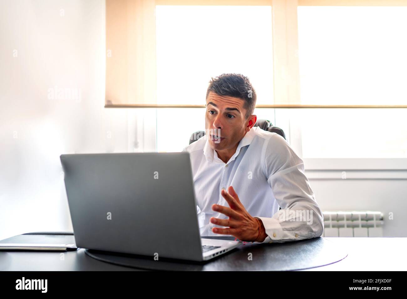 executive che ha una videochiamata mentre lavora da casa Foto Stock