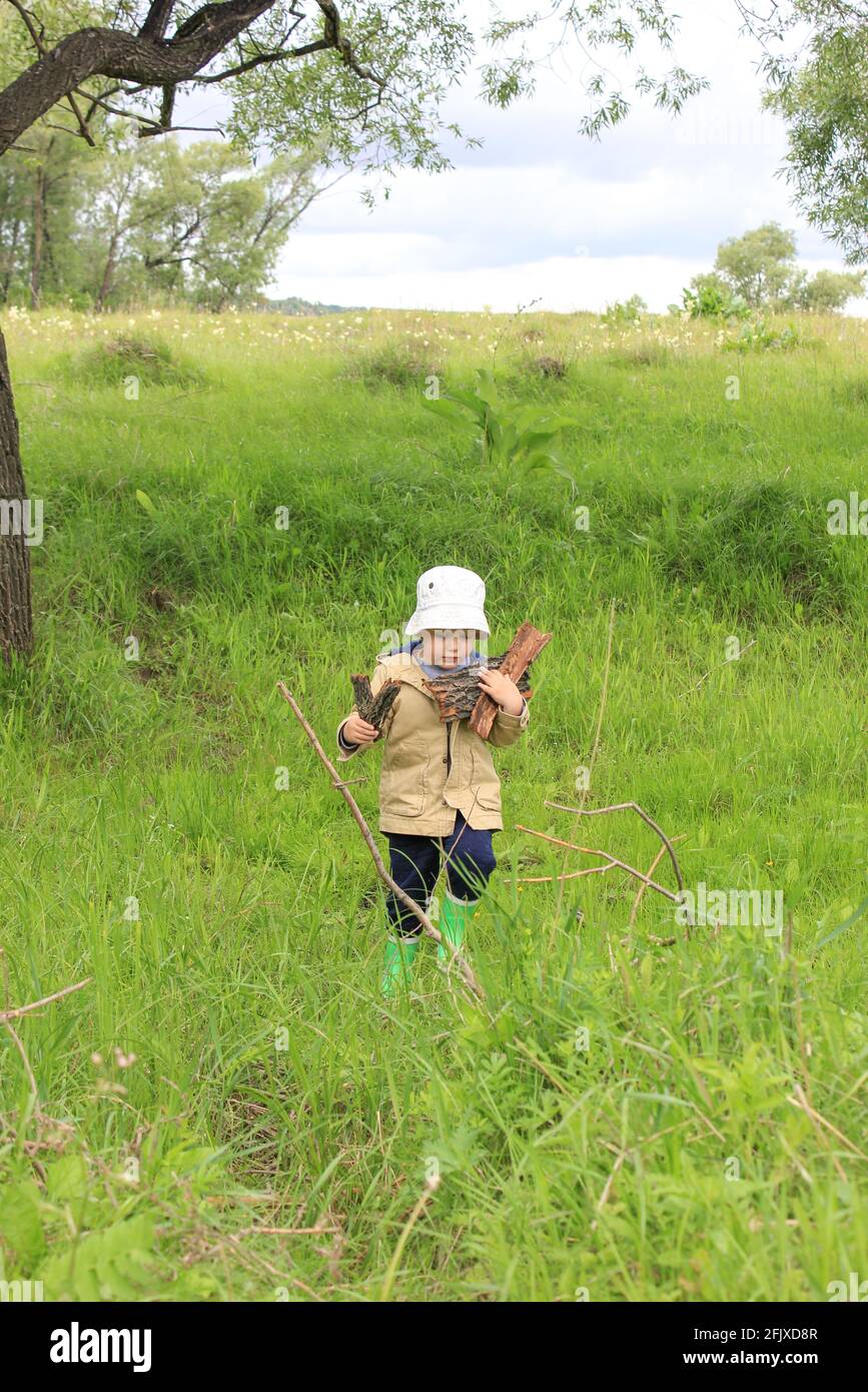 Un bambino di 3 anni cammina in un prato verde Foto Stock
