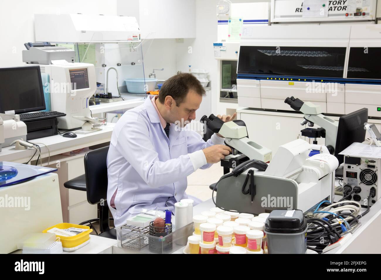 Un ricercatore lavora con il microscopio in un laboratorio. Foto Stock