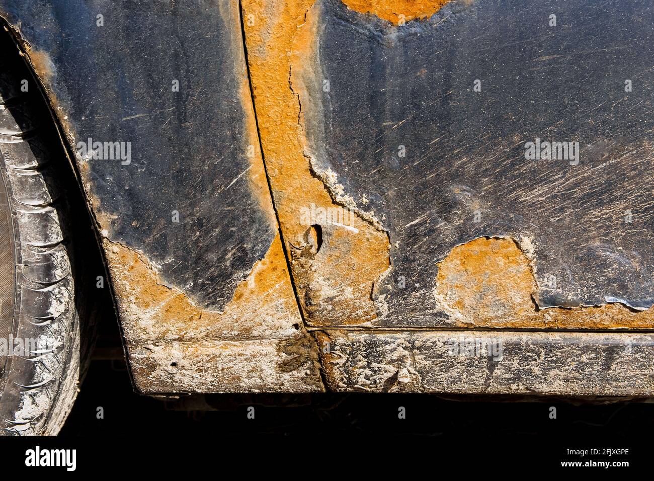 Tracce di ruggine e di usura sulla portiera del conducente di una vecchia vettura sporca danneggiata. Ammortamento dell'automobile. Foto Stock