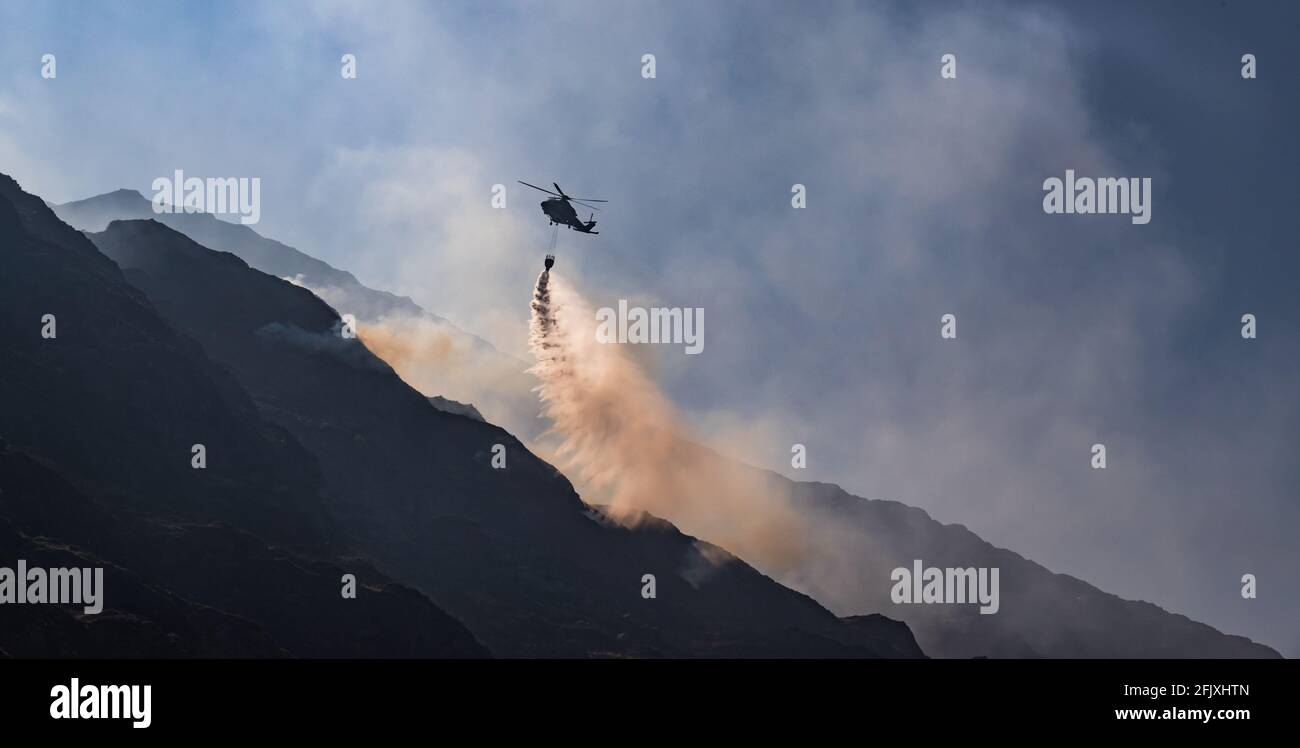 Killarney National Park, Irlanda - 26 aprile. 2021: L'elicottero Irish Air Corp scarica l'acqua per spegnere il fuoco nel parco nazionale di Killarney Foto Stock