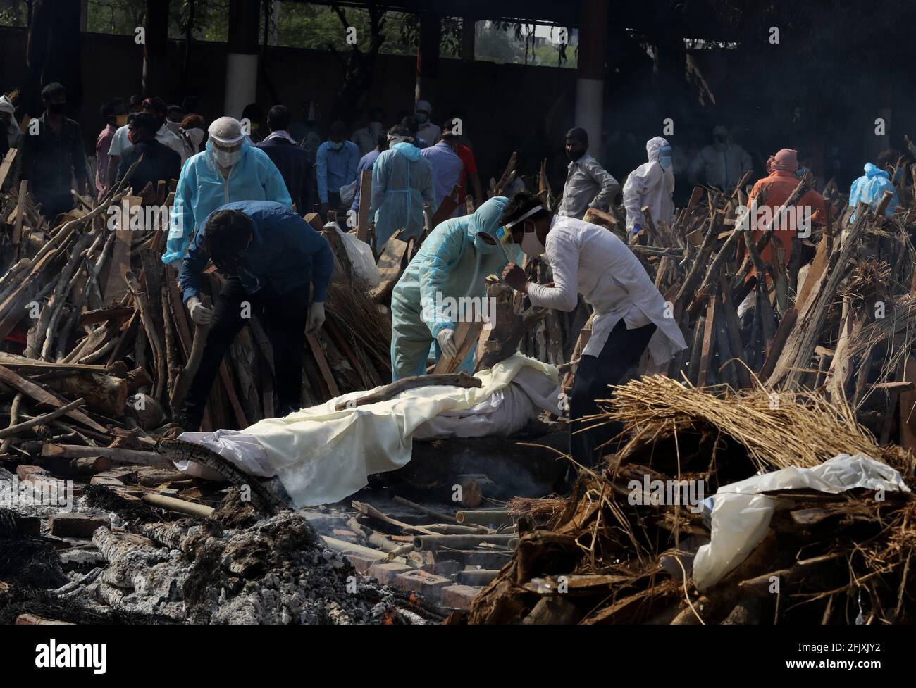 Nuova Delhi, India. 26 Apr 2021. (NOTA REDATTORI: Immagine raffigura la morte)i membri della famiglia pagano il loro ultimo rispetto ad un parenti che è morto dalla malattia di Covid19 prima della cremazione al terreno di cremazione di Ghazipur a Nuova Delhi. In India il picco più alto di un giorno nell'infezione da coronavirus. Il rapporto ha registrato 352,991 nuovi casi di Covid-19 e 2,812 decessi nelle ultime 24 ore nel corso di una crisi dell'ossigeno. Credit: SOPA Images Limited/Alamy Live News Foto Stock