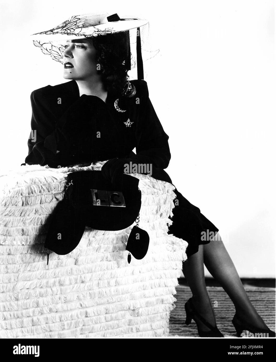 1940's : l'attrice GLORIA SWANSON ( 1898 - 1983 ) , Paramount publicity Still - FILM - CINEMA - attrice cinematografia - VAMP - DIVA - DIVINA - DIVINA - spalla - spalle - spalle - spilla - pin - gioielli - gioiello - gioiello - gioielli - gioielli - bijoux - bigiotteria - borsa - borsetta - borsa - neo - talpa - abito da passeggio - cappello - cappello - velo - veletta - luna - luna - stella - sandali - sandali - divano - divano - moda - guanti - guanti ---- Archivio GBB Foto Stock