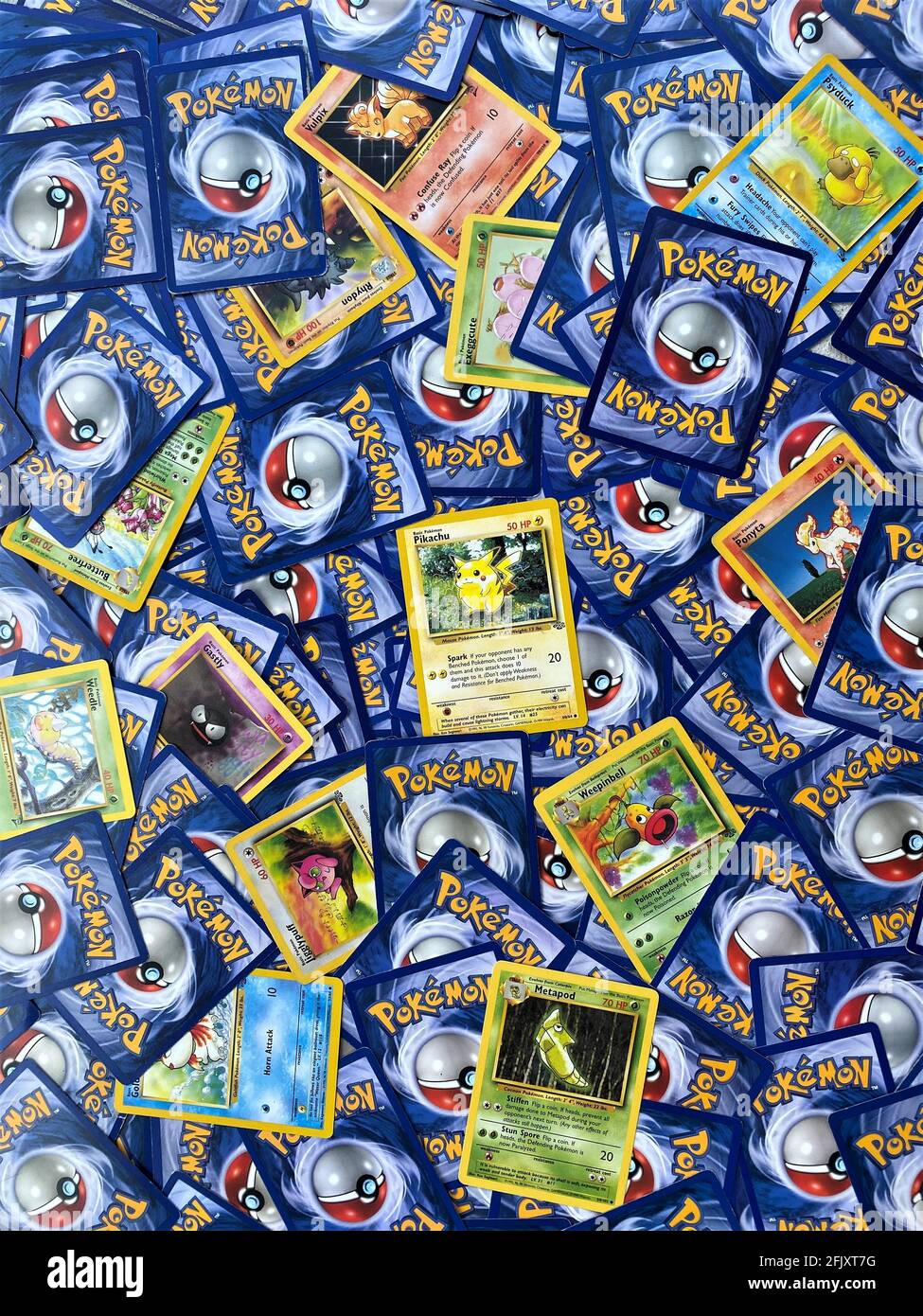 Pokemon gioco di carte di trading. Molte carte pokemon si spargono, come sfondo. Colorato. Mostra il carattere principale, Pikachu. Foto Stock