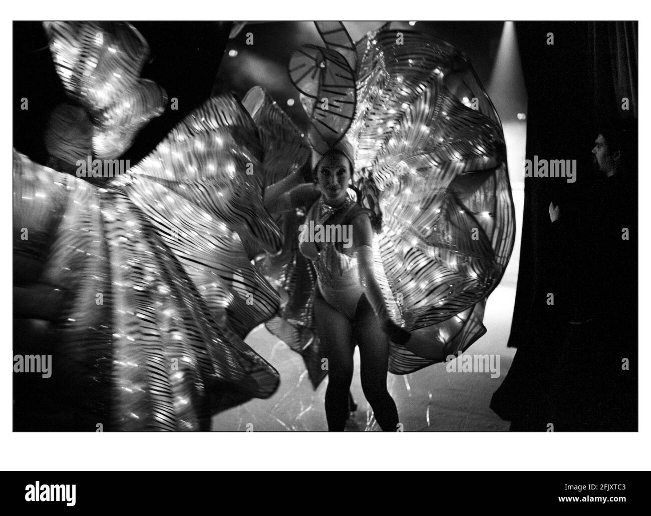 Con luci incandescenti nei loro costumi Febbraio 2000 performers scivola con grazia dietro il sipario all'aplause del finimento del croud un altro segmento della mostra Foto Stock