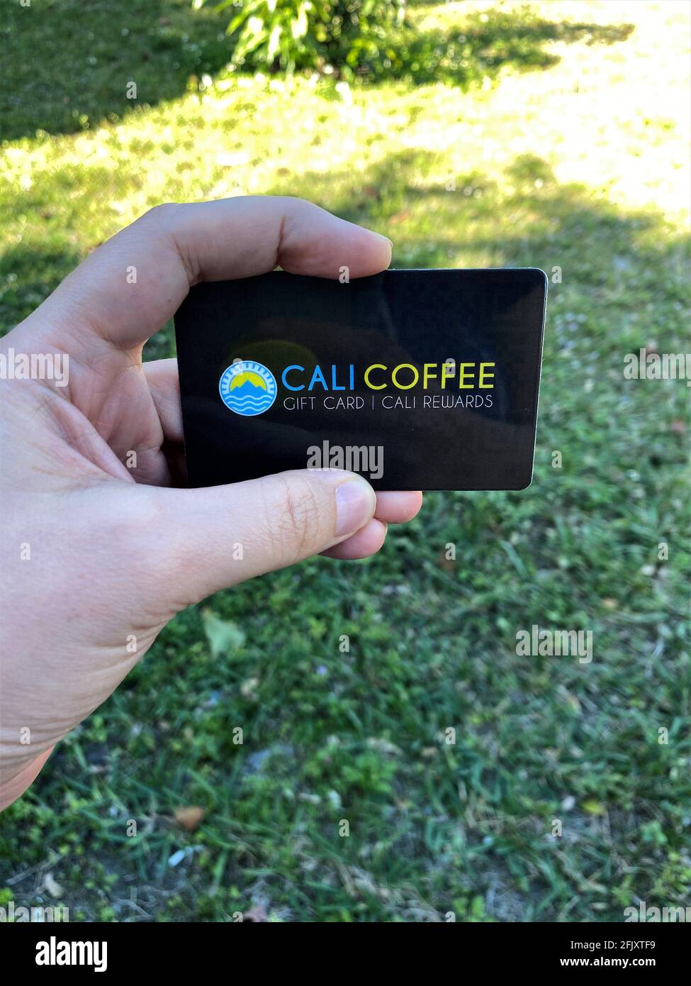 Una donna in possesso di una carta Cali Coffee Rewards che può essere utilizzata anche come carta regalo. Contea di Broward Foto Stock