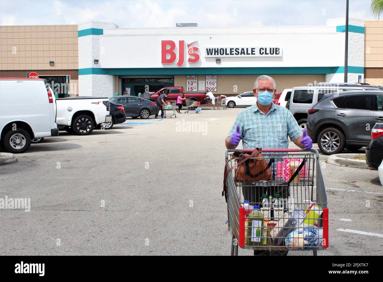 Uomo ispanico che indossa guanti di protezione e una maschera viso dopo Shopping al BJ's Wholesale Club Store durante il Coronavirus COVID-19 Focolaio a Miami A. Foto Stock