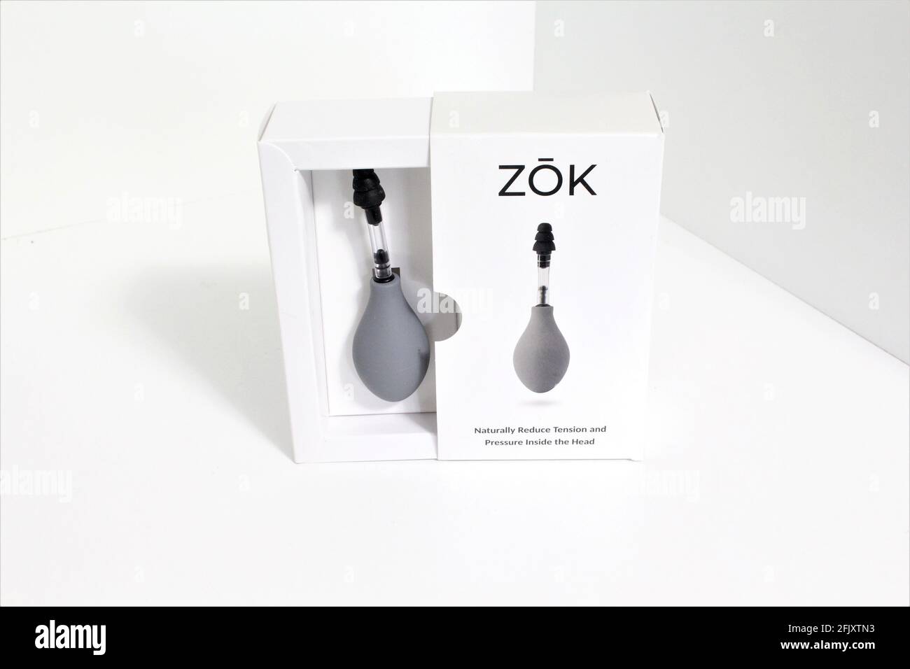 ZOK dispositivo che riduce naturalmente la pressione e la tensione all'interno della testa inserendo il dispositivo nell'orecchio e esercitando pressione. Emicrania relie Foto Stock