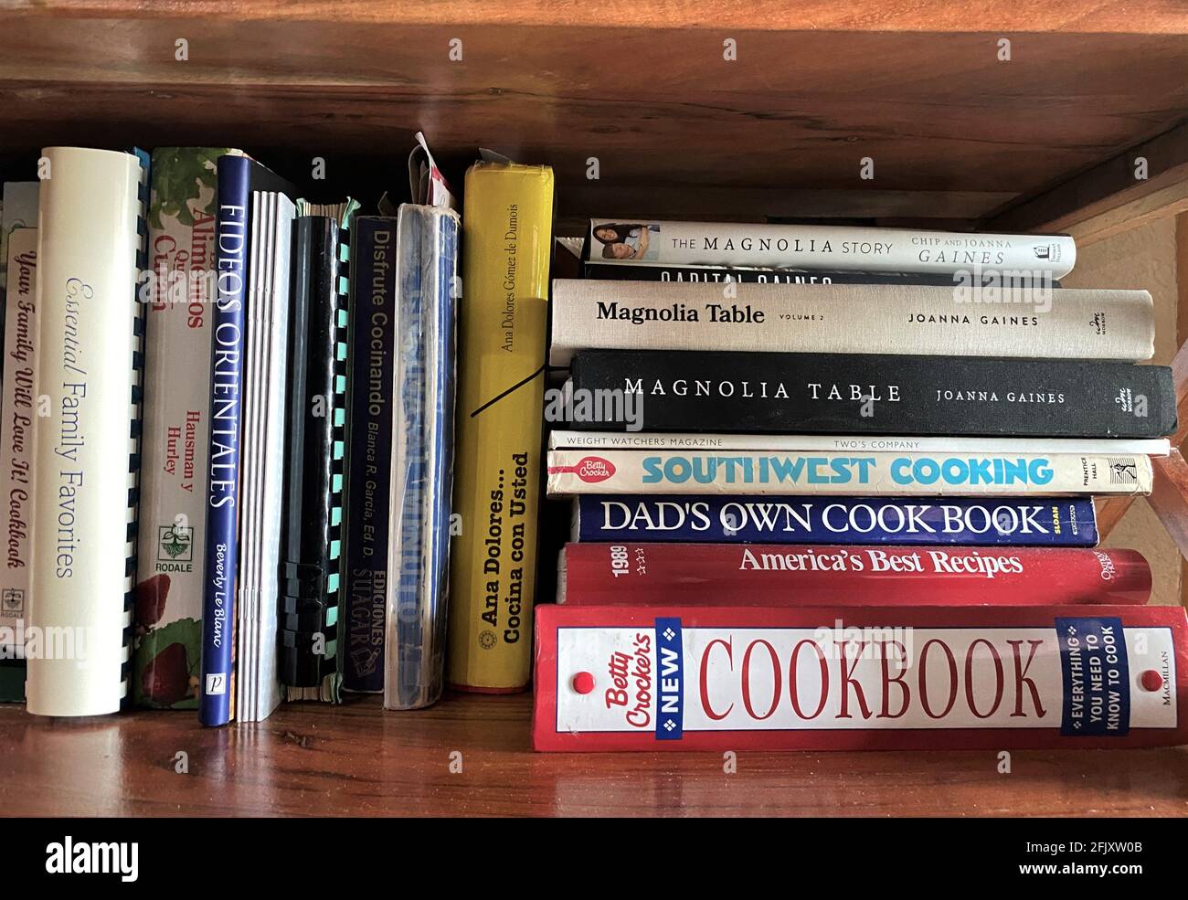 Cookbooks della cucina accatastati insieme sullo scaffale. Vengono mostrate molte cucine diverse. Foto Stock