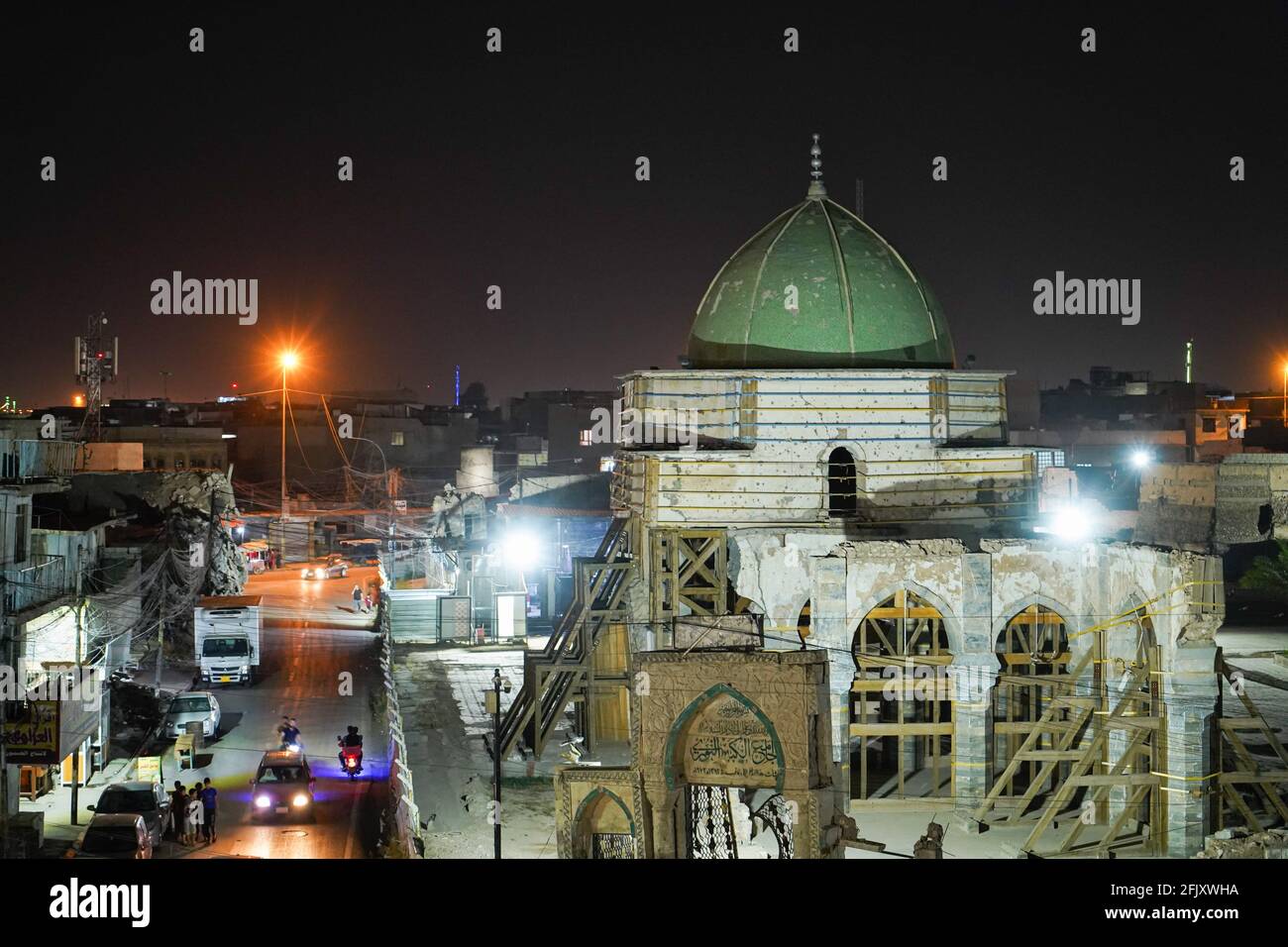 Mosul, Iraq. 26 Apr 2021. Una vista dal tetto di una casa distrutta mostra la moschea distrutta al-Nuri di notte. La Moschea al-Nuri fu costruita nel 1172 e che comprende anche il minareto di al-Hadba, è attualmente in fase di ricostruzione nel suo vecchio progetto da parte dell'UNESCO dopo essere stata distrutta durante la guerra contro l'Isis (Stato islamico dell'Iraq e della Siria). Credit: SOPA Images Limited/Alamy Live News Foto Stock