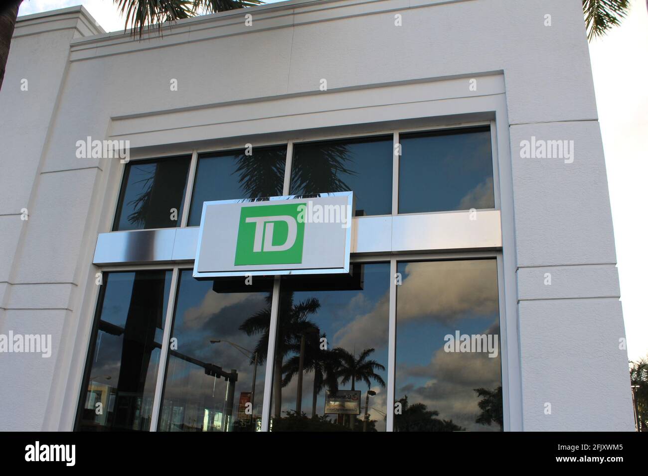 TD Bank (Toronto-Dominion Bank) in una banca di Miami, Florida. Le palme possono essere viste riflettendo sulle finestre di vetro. Foto Stock