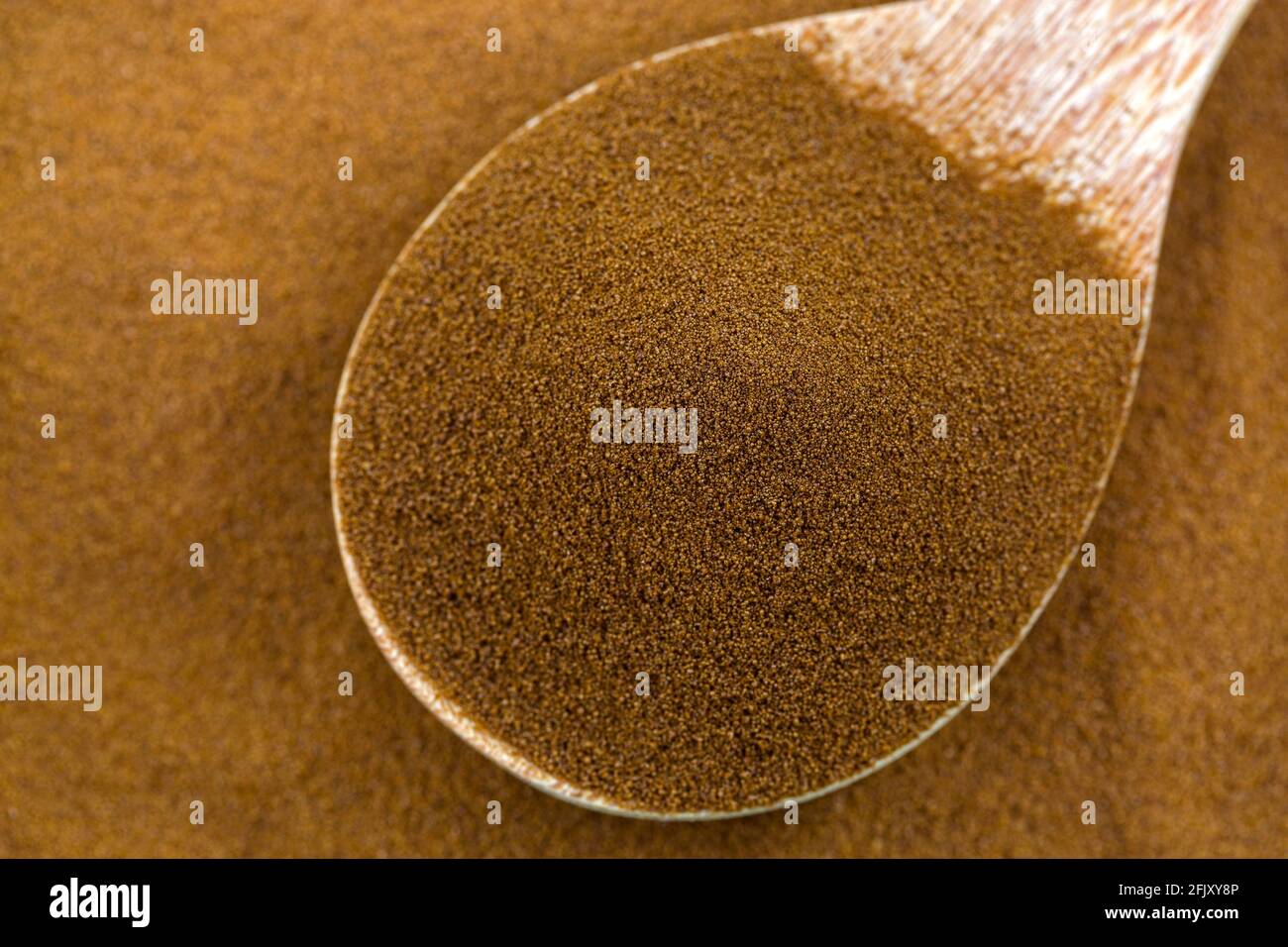 Caffè secco puro e istantaneo africano spray di robusta e chicchi di caffè arabica in cucchiaio di legno, vista dall'alto con texture closeup Foto Stock