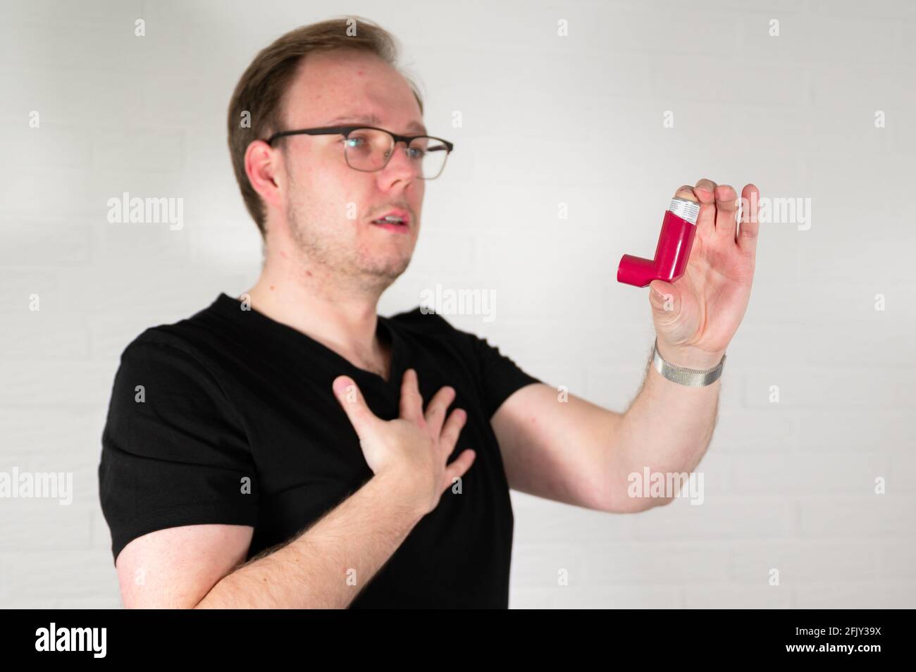 Uomo che usa un inalatore spray per asma Foto Stock