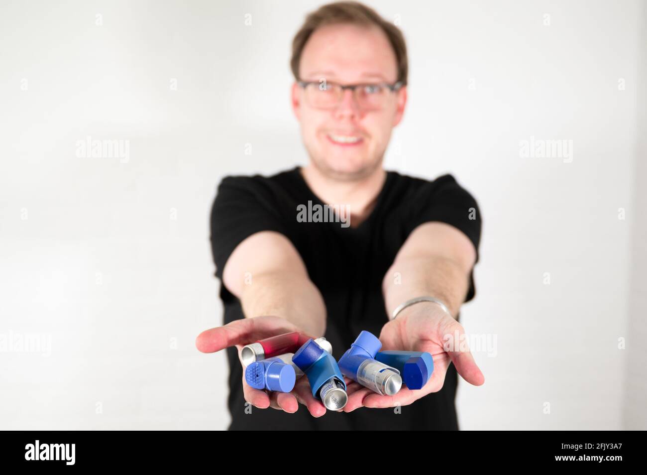 Uomo che usa un inalatore spray per asma Foto Stock