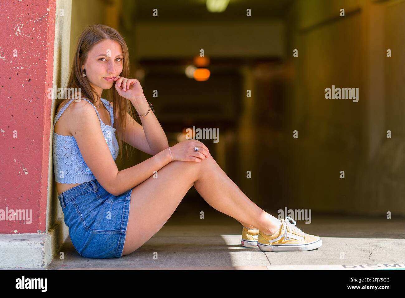 Giovane donna seduto a terra vicino a un tunnel pedonale Foto Stock