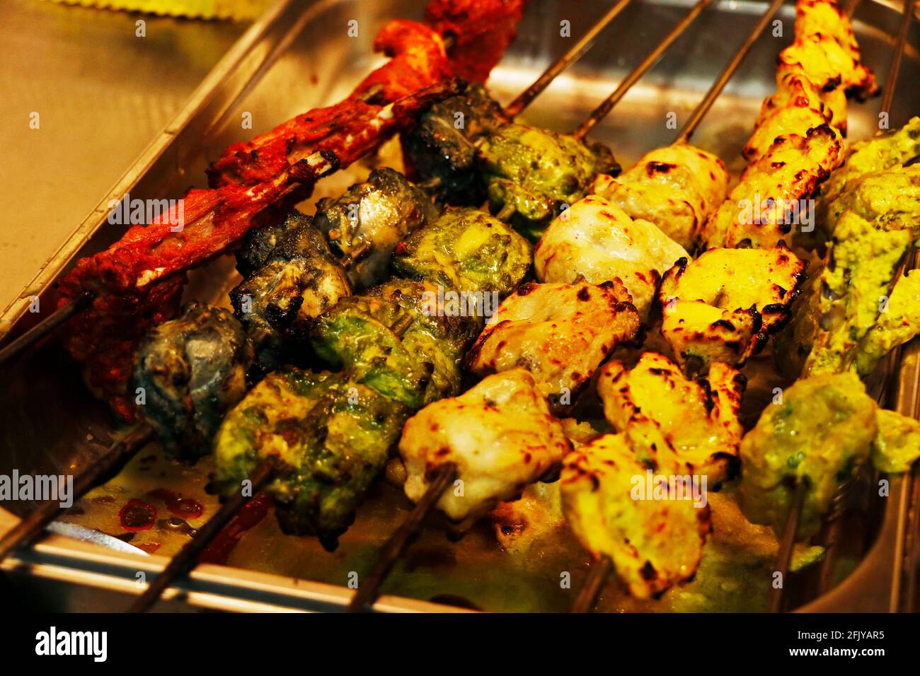 tandoori kebab o tikka indiani multicolore e aromatizzati in un prodotto alimentare da forno in argilla spiedino Foto Stock