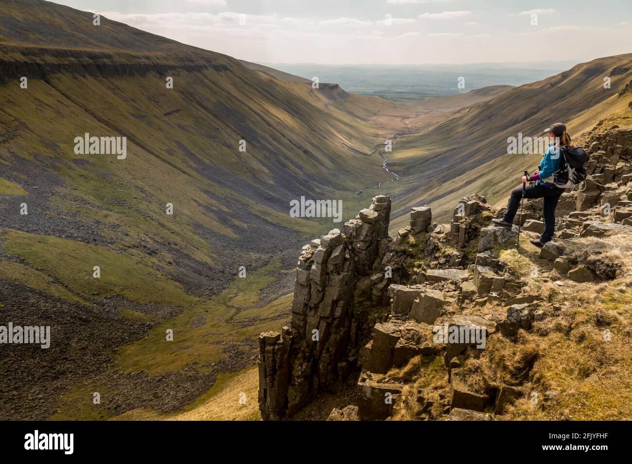 Un'escursionista solista si affaccia su High Cup Nick, una classica valle a forma di U nella zona di North Pennines in Inghilterra. Foto Stock