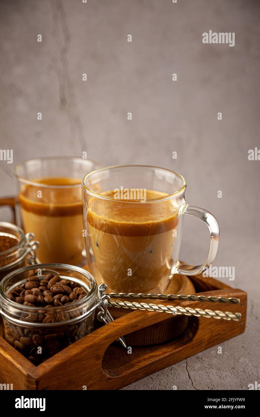 Dalgona Coffee - la bevanda coreana di caffè su sfondo di legno. Caffè istantaneo o espresso in polvere con zucchero e acqua calda. Algone montato ghiacciato Foto Stock