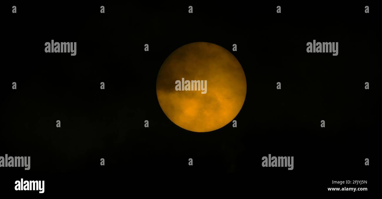 Londra, Regno Unito. 27 aprile 2021. Le nuvole si turbano oltre il sole mentre i gruppi di spot solari attivi in espansione 2818, 2820 e 2821 sono rivelati attraverso un telescopio solare. Credit: Malcolm Park/Alamy Live News Foto Stock