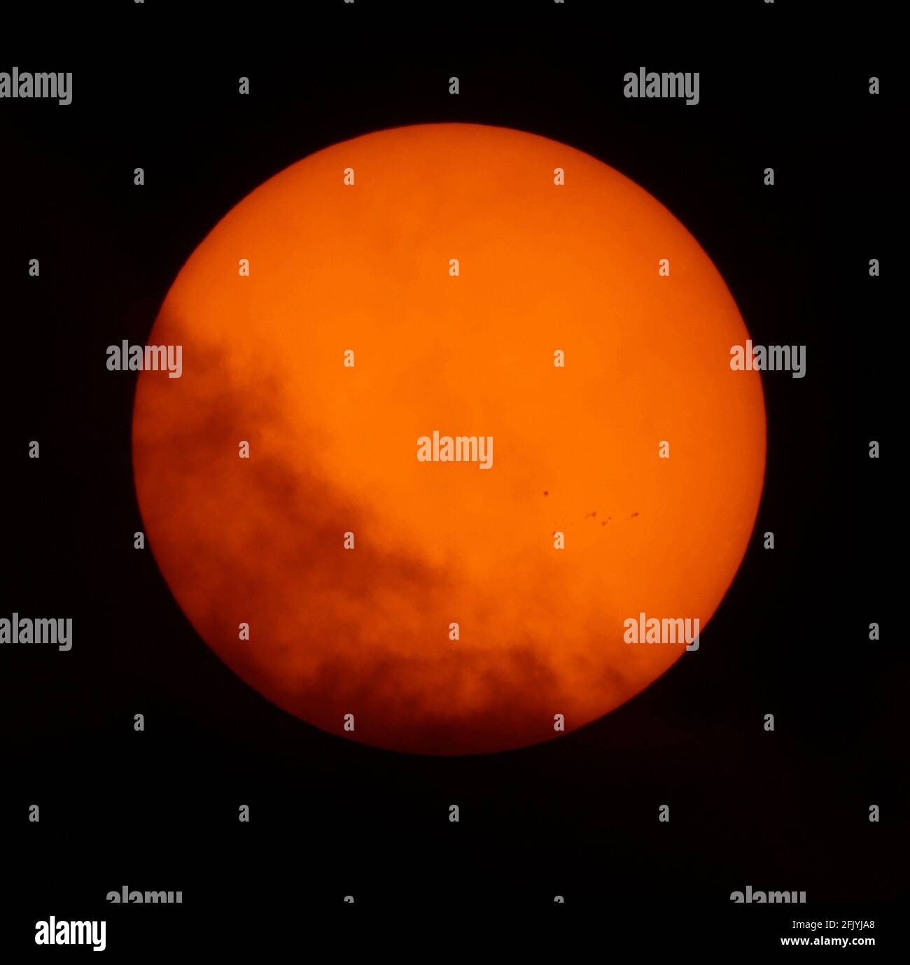 Londra, Regno Unito. 27 aprile 2021. Le nuvole si turbano oltre il sole mentre i gruppi di spot solari attivi in espansione 2818, 2820 e 2821 sono rivelati attraverso un telescopio solare. Credit: Malcolm Park/Alamy Live News Foto Stock