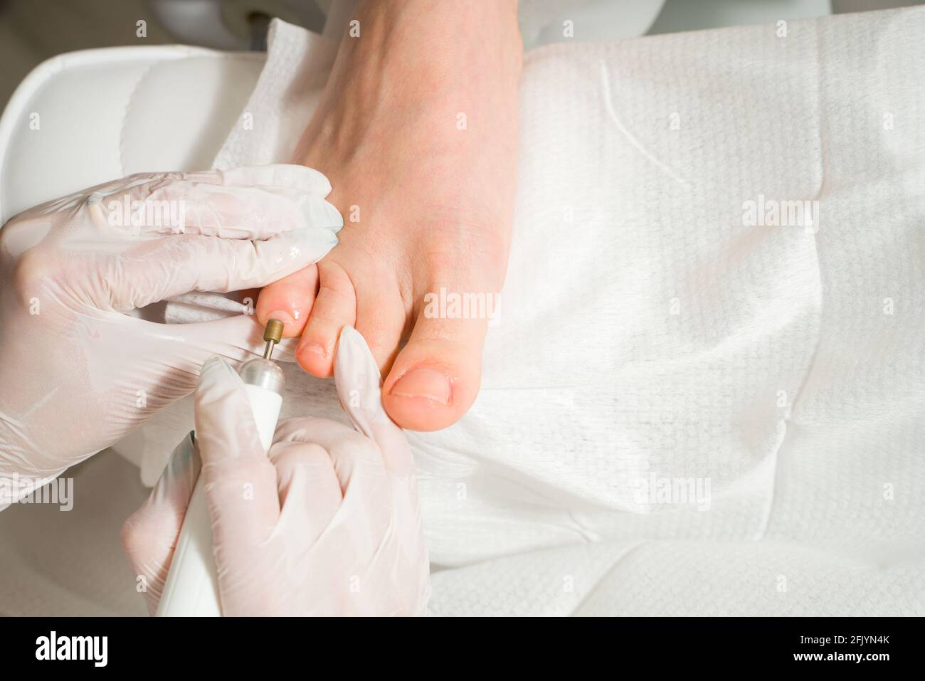 Un medico di podiatrist che si prende cura delle toenails di una donna. Procedure cosmetiche dei piedi Foto Stock