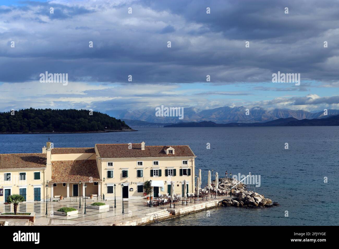 Città vecchia di Corfù, spiaggia di Faliraki. En PLO ristorante e guardando oltre l'isola di Vidos e la Grecia continentale. Settembre, appena dopo una tempesta di pioggia. Foto Stock