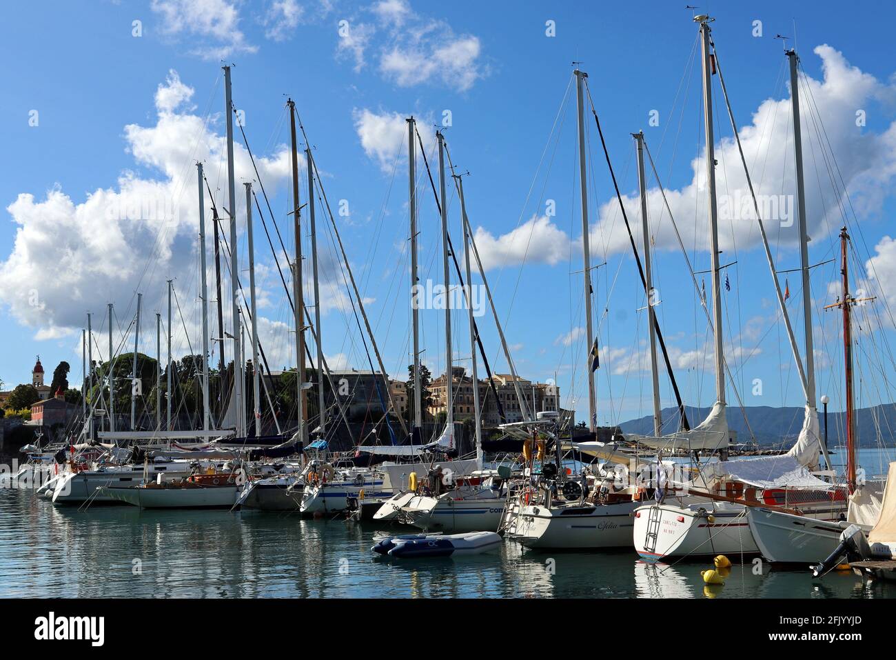 Barche ormeggiate sotto la città vecchia di Corfù. Sullo sfondo sono visibili l'architettura italiana sul lungomare e la chiesa di San Spyridon. Settembre. Foto Stock