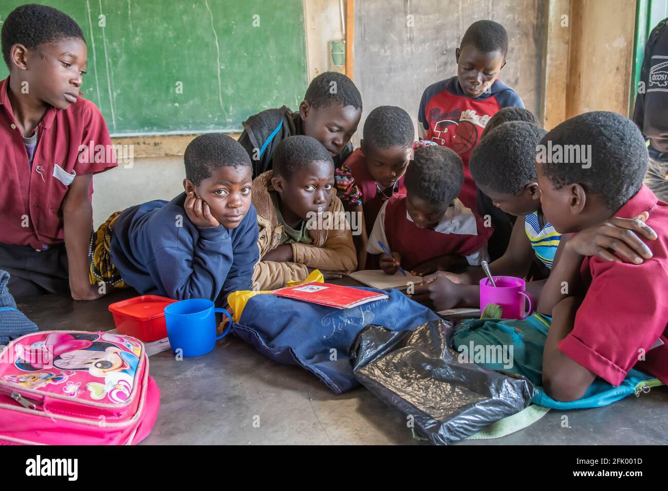 Mzuzu, Malawi. 30-05-2018. Un gruppo di bambini neri si riunì all'interno della loro classe lavorando su un saggio assegnato dal loro insegnante in una scuola in Malawi. Foto Stock