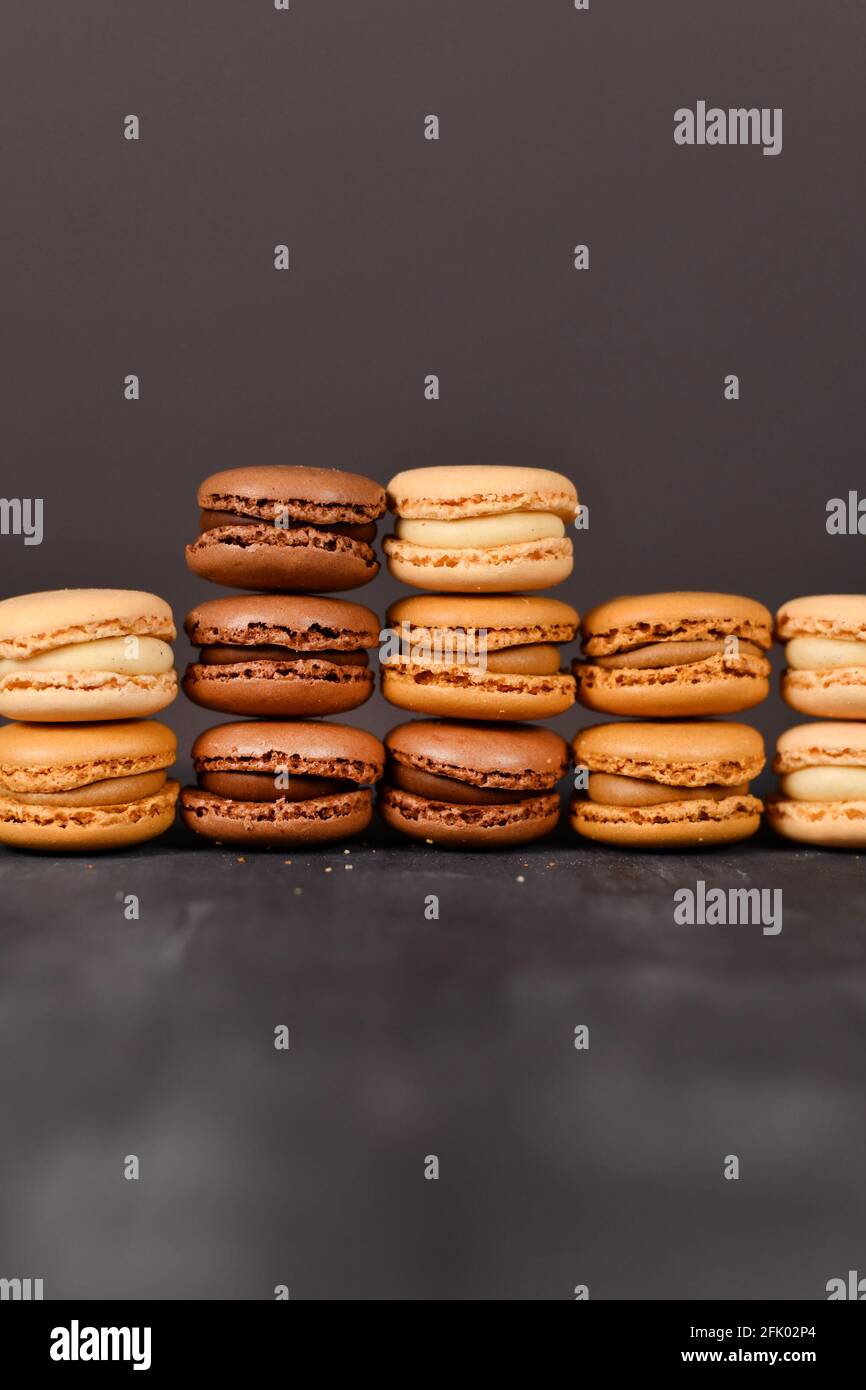 Pile di macaron francesi di colore marrone, beige e crema con spazio per la copia Foto Stock
