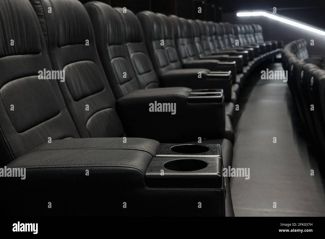 Sedili vuoti in pelle nera in fila al cinema - grande intrattenimento divertente immagine di sfondo Foto Stock