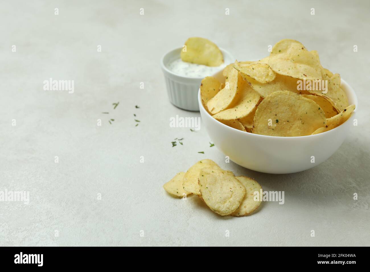 Gustosi patatine e salsa su fondo testurizzato bianco Foto Stock